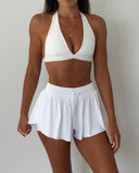 Woman wearing a white bikini set against a plain background