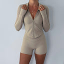 Beige athletic outfit with a jacket and shorts on a plain background